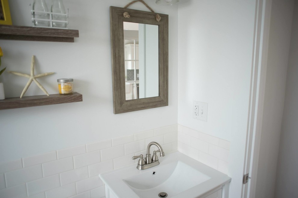 Inspiration for a mid-sized beach style 3/4 bathroom in Providence with shaker cabinets, white cabinets, a shower/bathtub combo, white tile, subway tile, white walls, porcelain floors and an integrated sink.