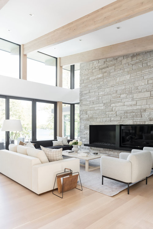 Large modern open concept living room in Salt Lake City with white walls, light hardwood floors, a standard fireplace and a built-in media wall.