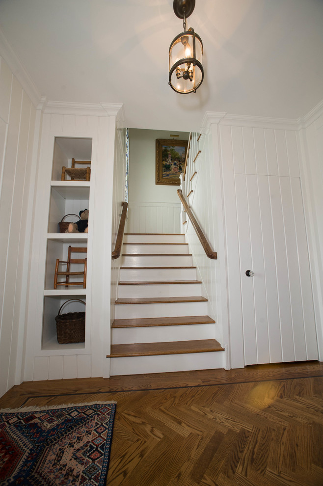 Photo of a mid-sized traditional wood u-shaped staircase in New York with painted wood risers and wood railing.