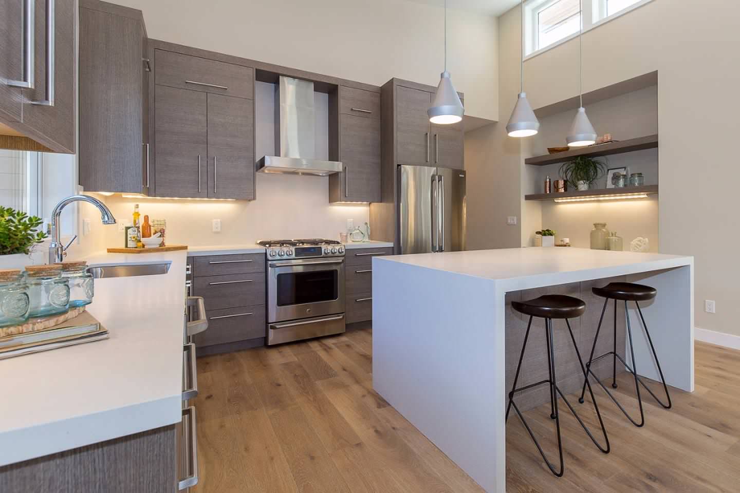 Example of a mid-sized trendy l-shaped medium tone wood floor and brown floor kitchen design in San Francisco with an undermount sink, flat-panel cabinets, medium tone wood cabinets, quartz countertop