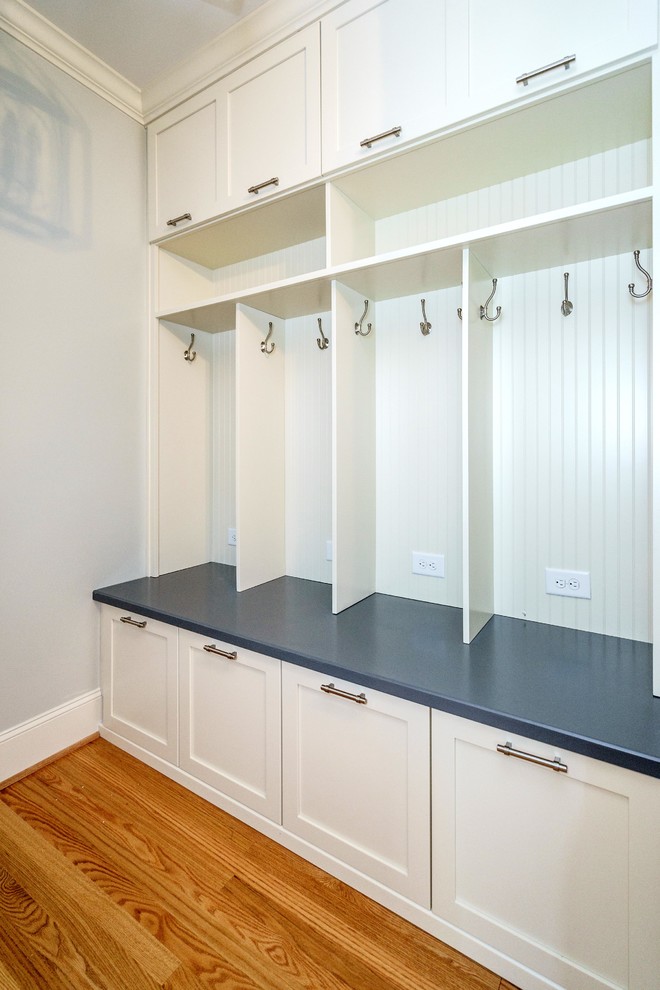This is an example of a mid-sized contemporary mudroom in Raleigh with grey walls, medium hardwood floors, a single front door and a metal front door.