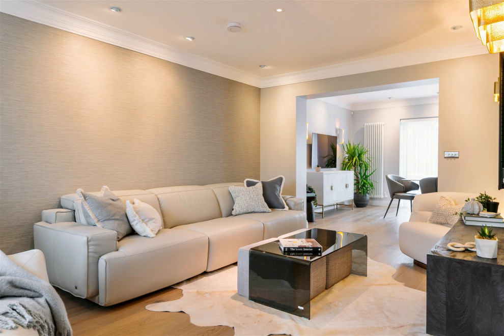 Идея дизайна: открытая гостиная комната в современном стиле с серыми стенами, светлым паркетным полом, телевизором на стене и обоями на стенах