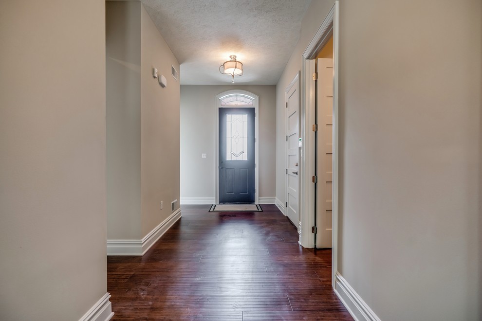 Inspiration for a transitional bamboo floor and brown floor entry hall remodel with beige walls and a brown front door