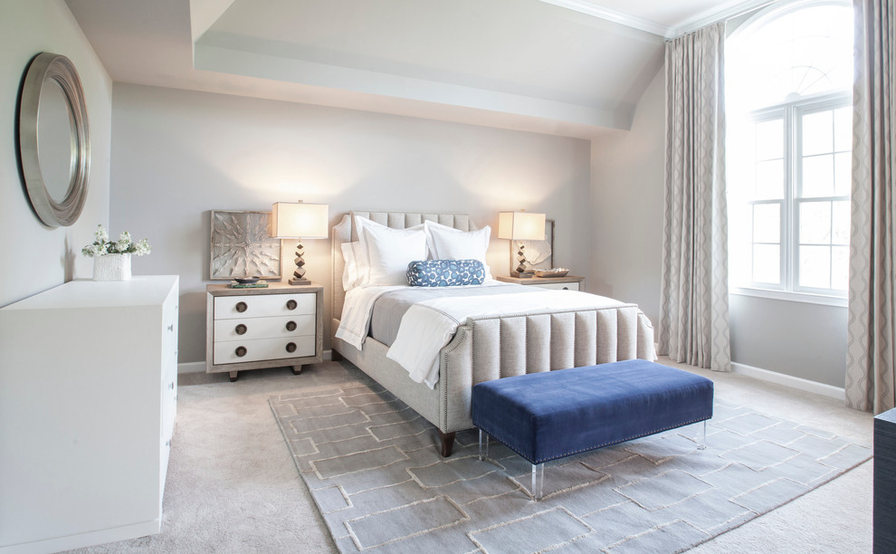 This is an example of a transitional master bedroom in Charlotte with white walls and carpet.