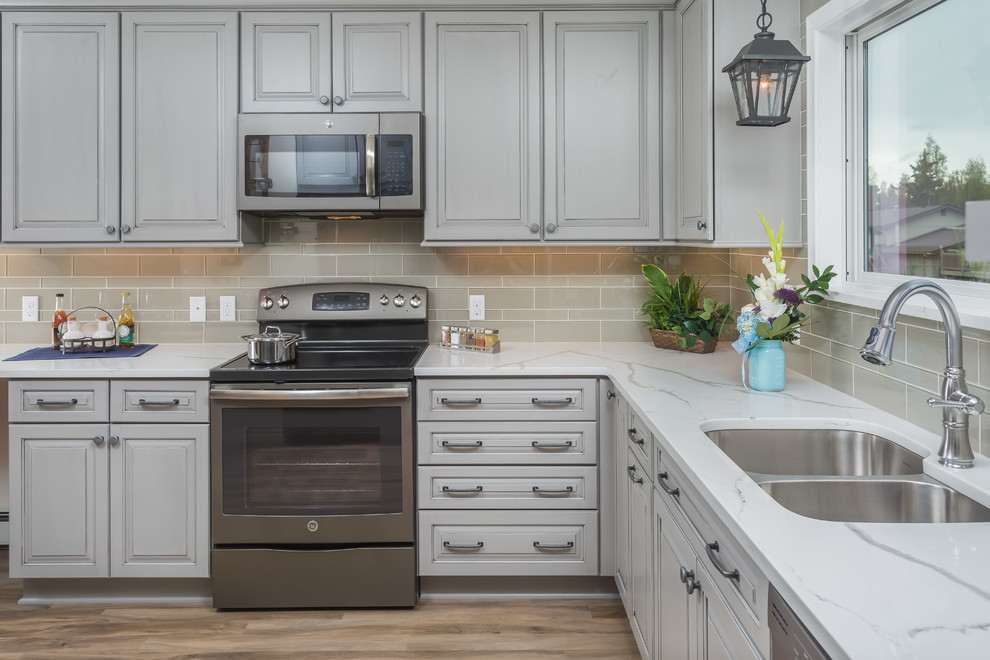 Inspiration for a small transitional l-shaped vinyl floor kitchen pantry remodel with an undermount sink, raised-panel cabinets, gray cabinets, quartz countertops, gray backsplash, glass tile backsplash, colored appliances and a peninsula