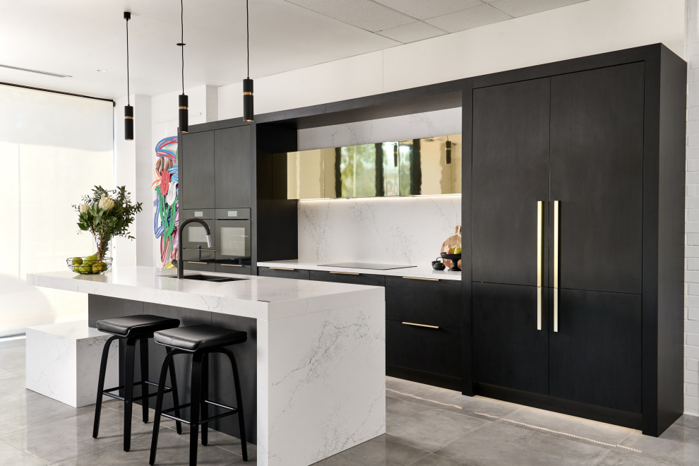 Photo of a contemporary galley kitchen in Perth with an undermount sink, flat-panel cabinets, black cabinets, white splashback, stone slab splashback, black appliances, with island, grey floor and white benchtop.