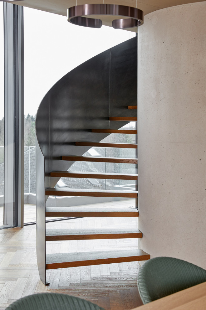 Ejemplo de escalera curva actual grande con escalones de madera pintada y barandilla de metal