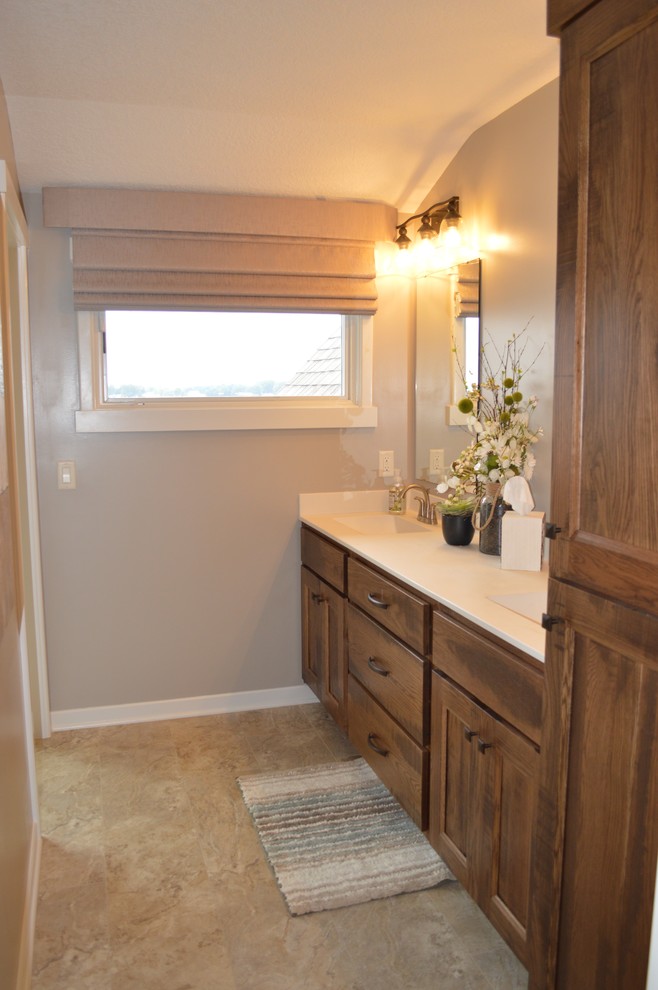 This is an example of a mid-sized transitional master bathroom in Grand Rapids with recessed-panel cabinets, distressed cabinets, a corner shower, a one-piece toilet, beige tile, ceramic tile, beige walls, linoleum floors, an integrated sink, engineered quartz benchtops, beige floor and an open shower.
