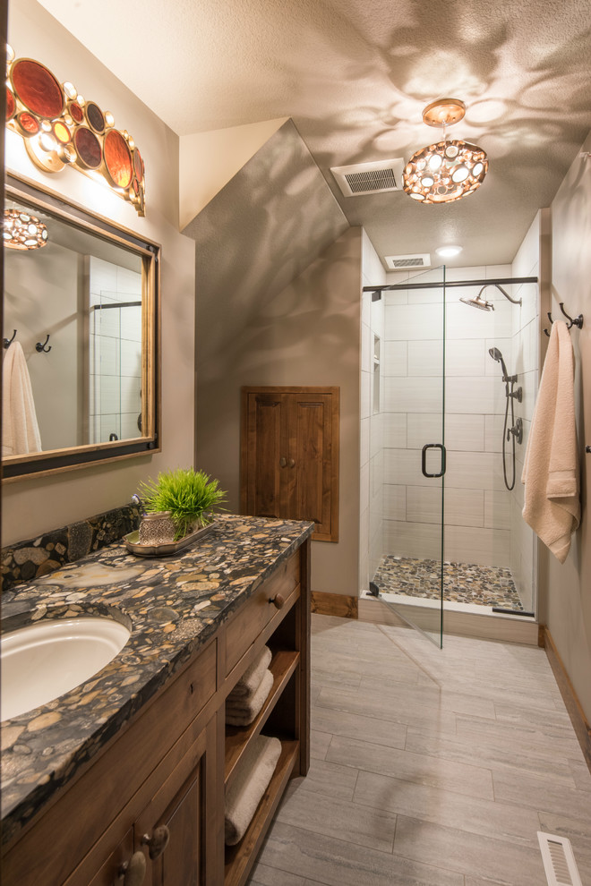 This is an example of a mid-sized country 3/4 bathroom in Minneapolis with raised-panel cabinets, dark wood cabinets, a corner shower, a two-piece toilet, white tile, subway tile, beige walls, travertine floors, an undermount sink, granite benchtops, beige floor and a hinged shower door.