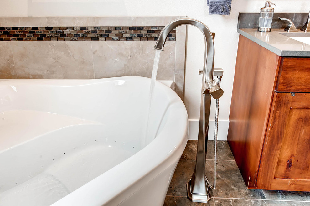 Mid-sized transitional gray tile and porcelain tile porcelain tile corner bathtub photo in Denver with shaker cabinets, medium tone wood cabinets, a one-piece toilet, gray walls, an undermount sink and solid surface countertops