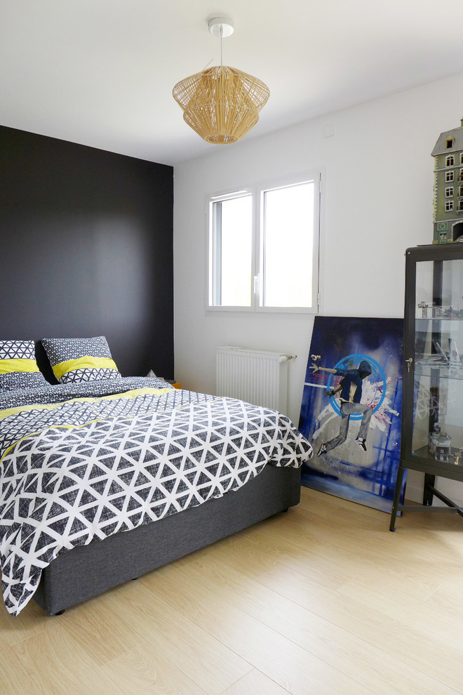 Photo of a mid-sized contemporary kids' room in Montpellier with black walls, light hardwood floors and beige floor.