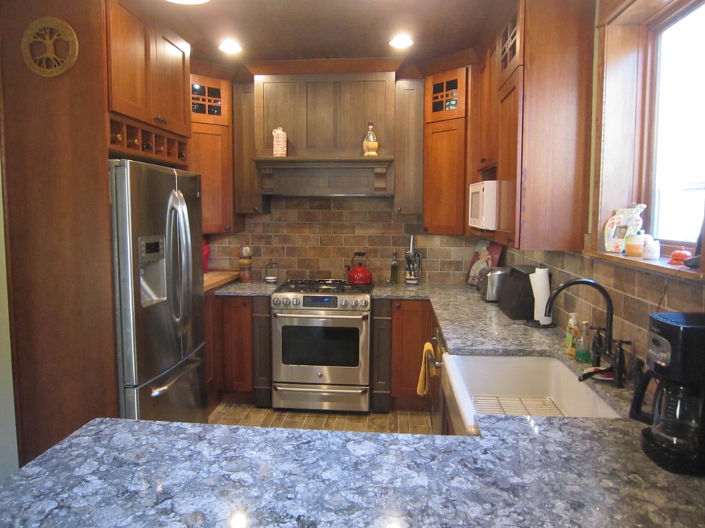 Example of a mid-sized mountain style u-shaped porcelain tile and brown floor eat-in kitchen design in Chicago with a farmhouse sink, shaker cabinets, porcelain backsplash, stainless steel appliances, a peninsula, dark wood cabinets, quartz countertops and brown backsplash