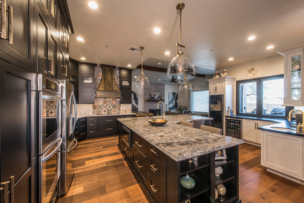 Inspiration for a huge transitional medium tone wood floor and brown floor kitchen remodel in Phoenix with an undermount sink, beaded inset cabinets, black cabinets, quartz countertops, white backsplash, subway tile backsplash, stainless steel appliances, an island and white countertops