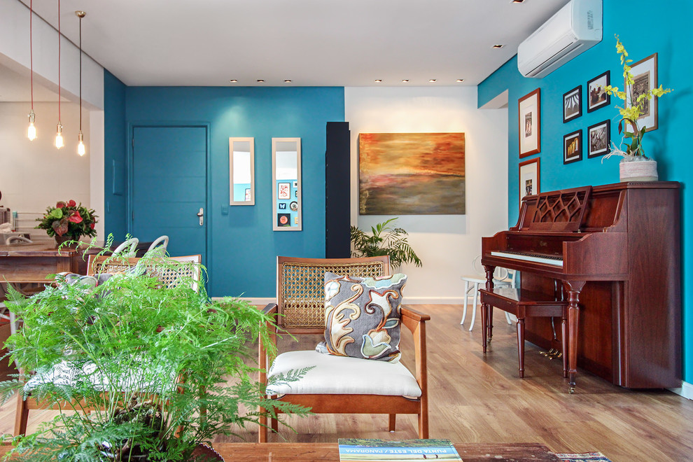 Photo of a large tropical foyer in Montpellier with blue walls, medium hardwood floors, a single front door, a blue front door and brown floor.
