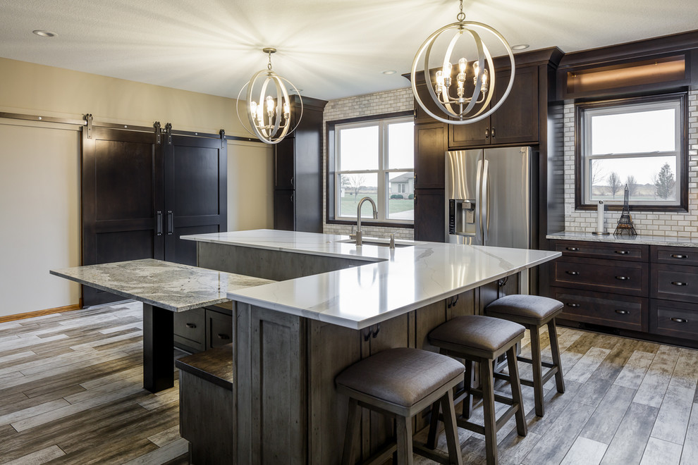 Example of a mid-sized transitional l-shaped ceramic tile and multicolored floor eat-in kitchen design with an undermount sink, shaker cabinets, medium tone wood cabinets, quartz countertops, white backsplash, marble backsplash, stainless steel appliances, an island and white countertops