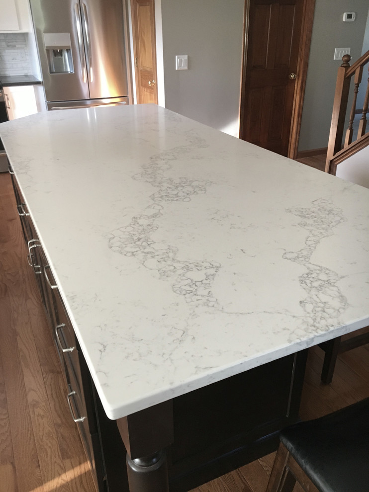 Eat-in kitchen - large transitional single-wall medium tone wood floor eat-in kitchen idea with an undermount sink, shaker cabinets, white cabinets, granite countertops, multicolored backsplash, marble backsplash, stainless steel appliances, an island and black countertops