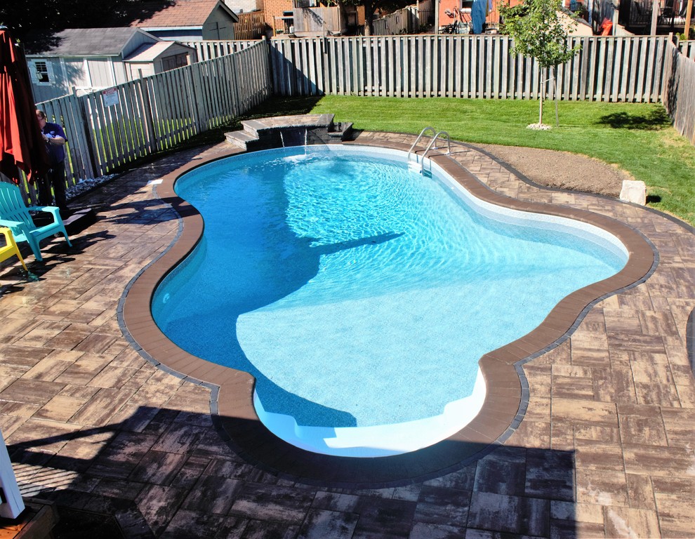 Pool - mid-sized transitional backyard concrete paver and custom-shaped lap pool idea in Toronto