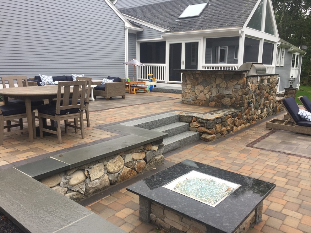 Photo of a mid-sized traditional backyard partial sun garden in Boston with a fire feature and concrete pavers.