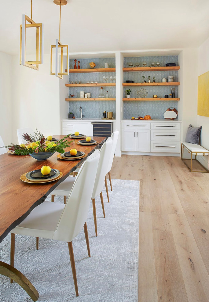 Photo of a large transitional kitchen/dining combo in San Francisco with white walls, light hardwood floors, a corner fireplace, a plaster fireplace surround and white floor.
