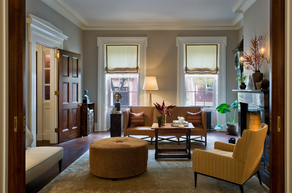 Example of a mid-sized classic enclosed and formal dark wood floor and brown floor living room design in New York with beige walls, a standard fireplace and no tv