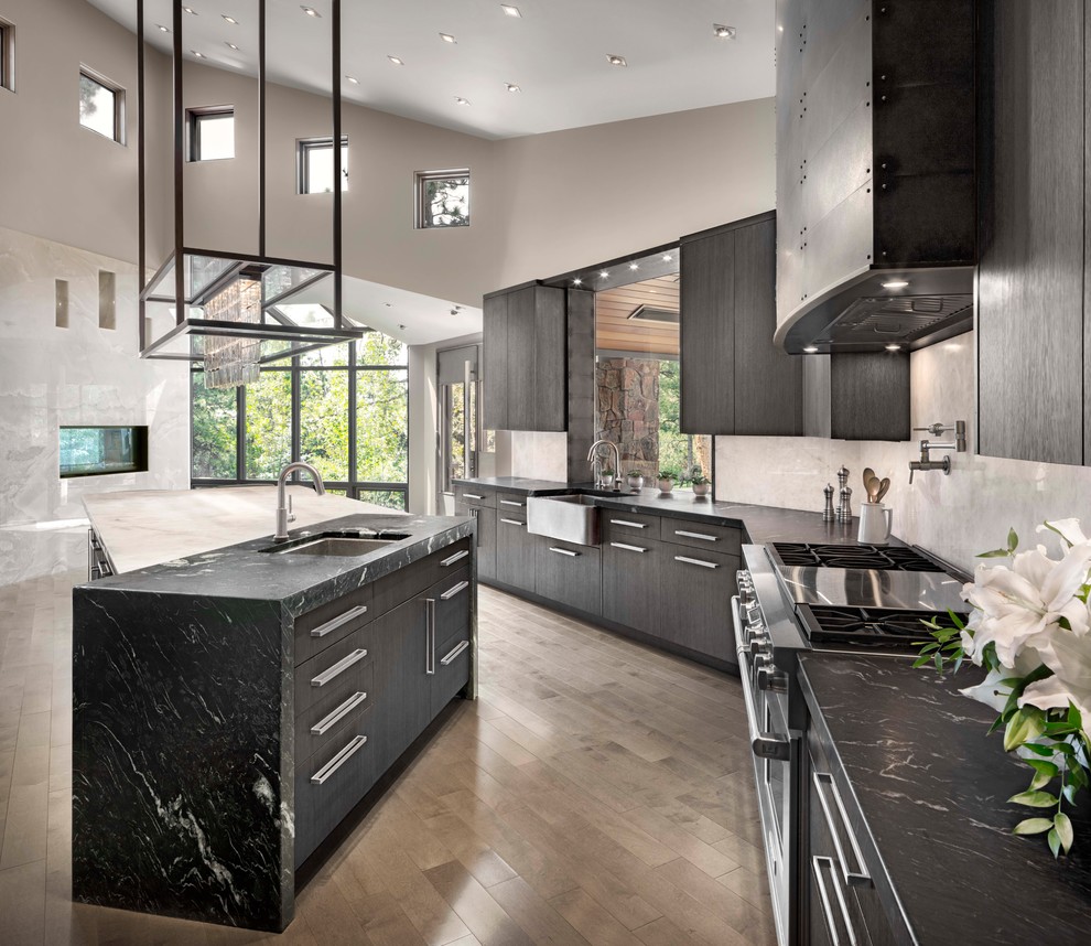 Inspiration for a contemporary galley kitchen in Denver with an undermount sink, flat-panel cabinets, grey cabinets, stainless steel appliances, medium hardwood floors, with island and brown floor.
