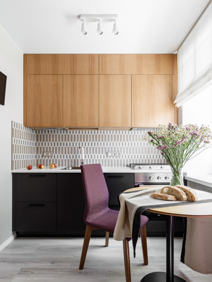This is an example of a scandinavian single-wall separate kitchen in Saint Petersburg with a drop-in sink, flat-panel cabinets, beige splashback, stainless steel appliances, grey floor and white benchtop.