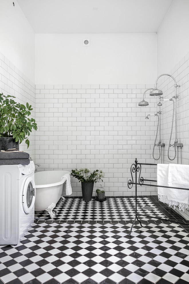 Inspiration for a large traditional 3/4 bathroom in Malmo with a claw-foot tub, a double shower, white walls, white tile, black floor, an open shower and a laundry.