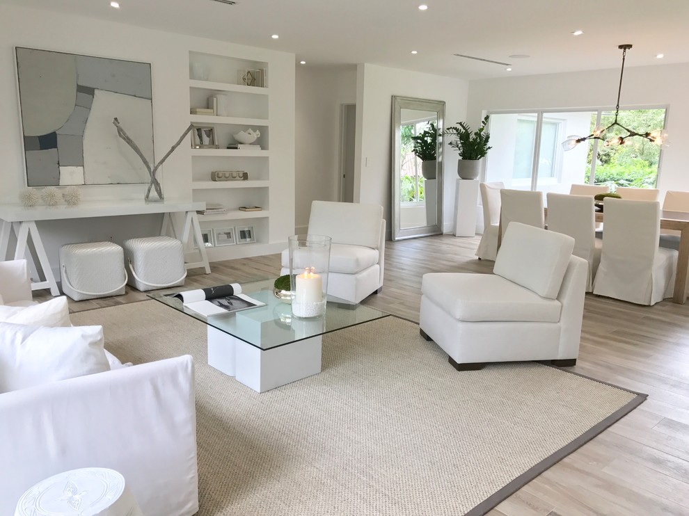 Design ideas for a large transitional open concept family room in Miami with white walls, light hardwood floors, no fireplace, no tv and brown floor.