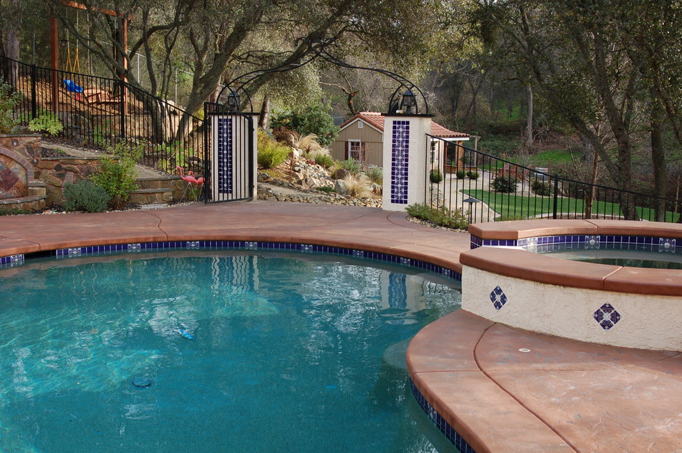 Design ideas for a large traditional backyard custom-shaped pool in Sacramento with stamped concrete.