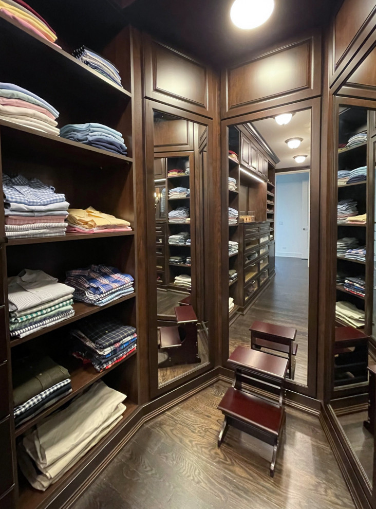 Diseño de armario vestidor de hombre clásico de tamaño medio con armarios con paneles con relieve y puertas de armario de madera en tonos medios