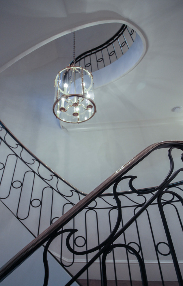 Inspiration for a large transitional wooden curved metal railing staircase remodel in DC Metro with wooden risers