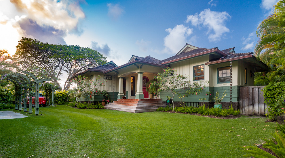 This is an example of a mid-sized arts and crafts one-storey green house exterior in Hawaii with concrete fiberboard siding, a hip roof and a shingle roof.