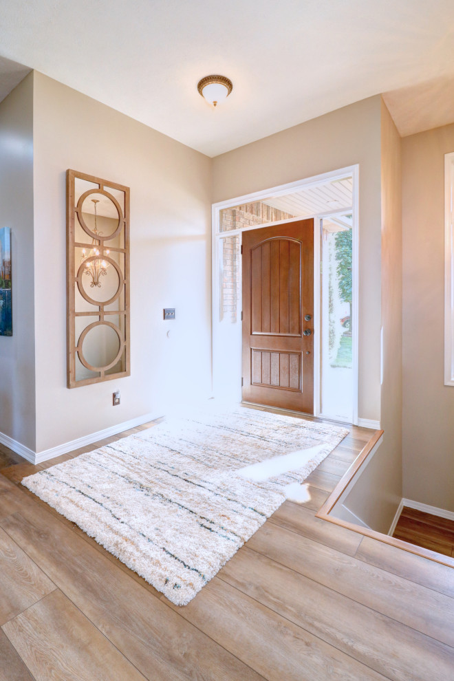 Example of a transitional vinyl floor single front door design with gray walls and a brown front door