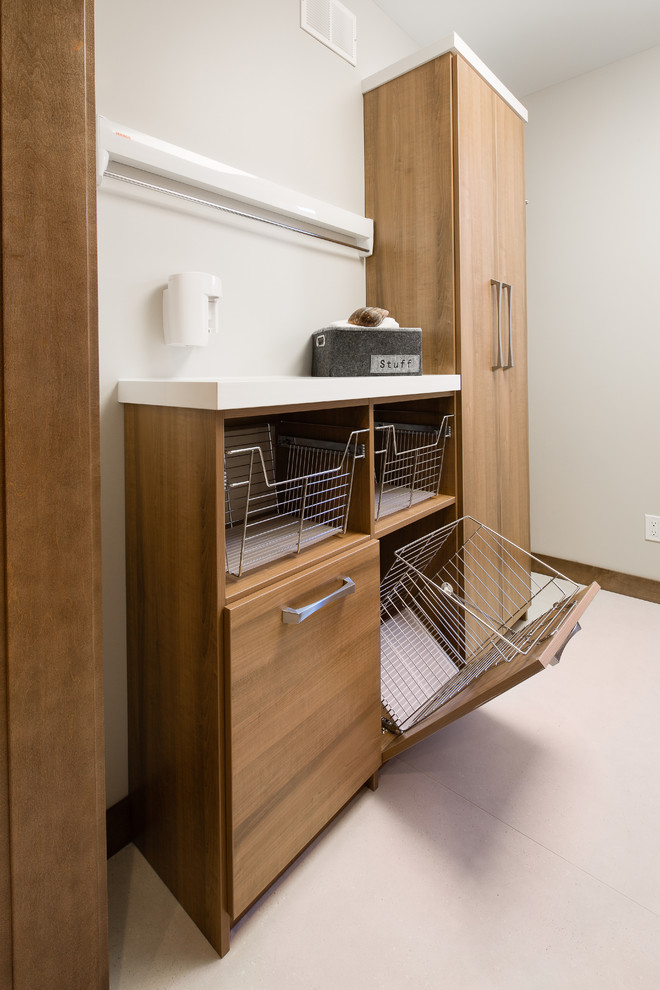 This is an example of a large contemporary galley dedicated laundry room in Other with medium wood cabinets, white walls, a side-by-side washer and dryer, flat-panel cabinets and vinyl floors.