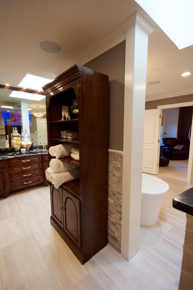 Design ideas for a large contemporary master bathroom in Austin with beaded inset cabinets, dark wood cabinets, a freestanding tub, an open shower, a bidet, beige tile, beige walls, ceramic floors, a drop-in sink and granite benchtops.