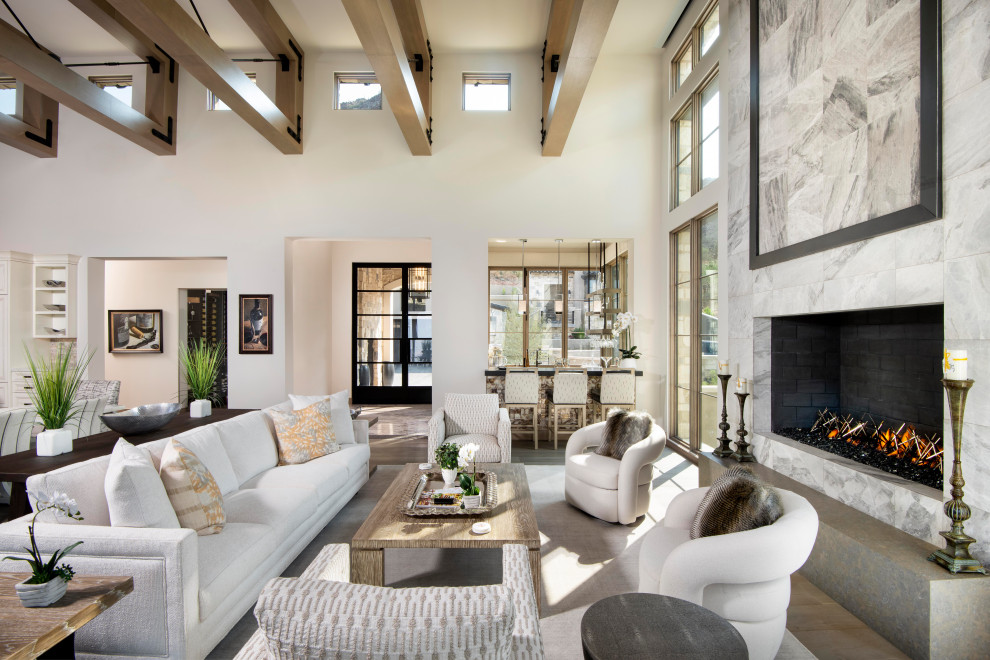 Transitional open concept medium tone wood floor, brown floor and exposed beam living room photo in Phoenix with white walls and a standard fireplace