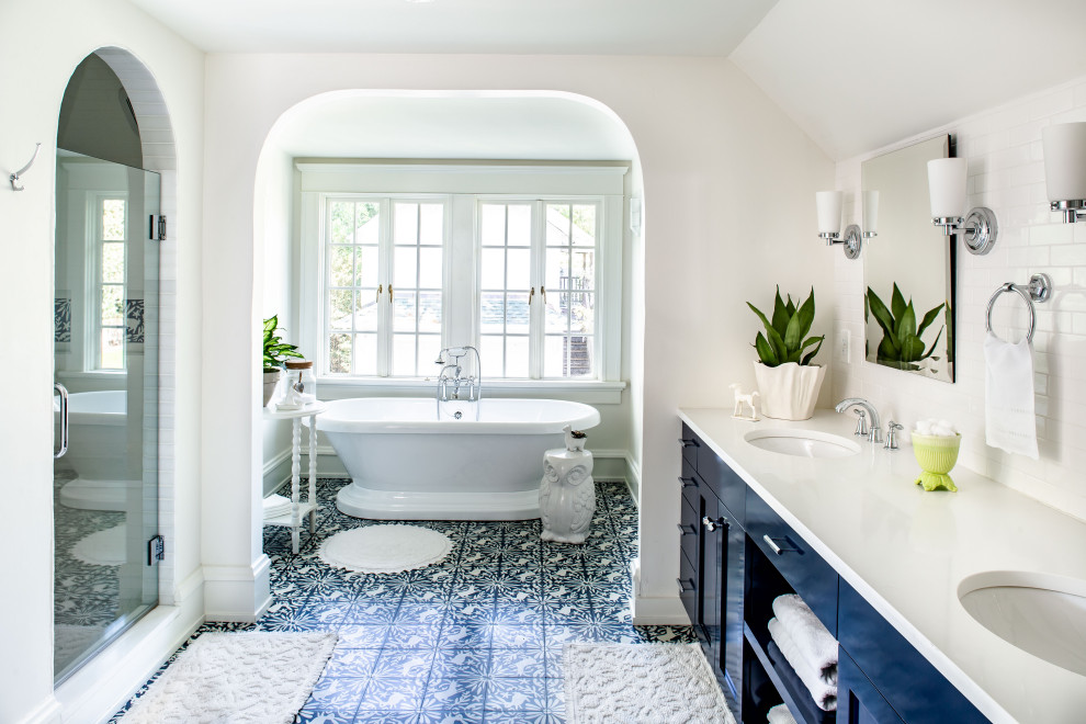 Traditional master bathroom in Atlanta with shaker cabinets, blue cabinets, a freestanding tub, white tile, white walls, an undermount sink, blue floor, white benchtops, a double vanity and a built-in vanity.