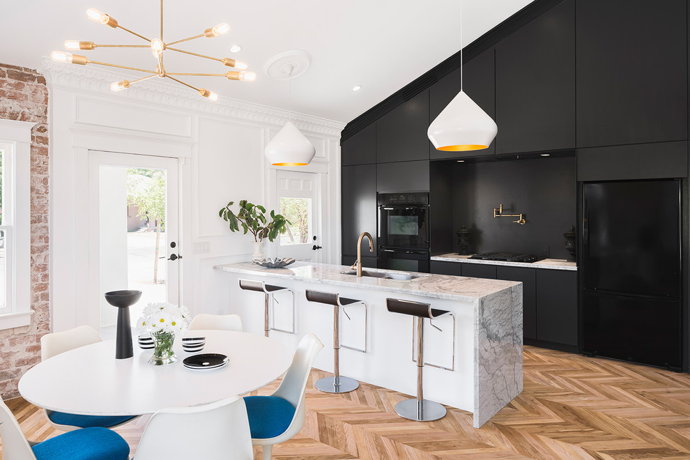 Inspiration for a contemporary galley eat-in kitchen in Phoenix with an undermount sink, flat-panel cabinets, dark wood cabinets, black appliances, light hardwood floors and with island.