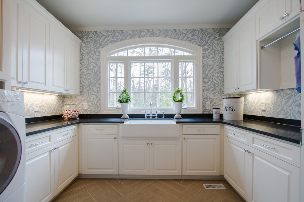 This is an example of a traditional laundry room in Atlanta with a farmhouse sink and white cabinets.
