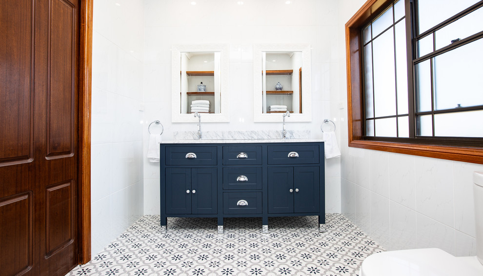 Inspiration for a large contemporary master bathroom in Sydney with furniture-like cabinets, blue cabinets, an open shower, a one-piece toilet, white tile, ceramic tile, white walls, ceramic floors, an undermount sink, granite benchtops, blue floor, an open shower and blue benchtops.