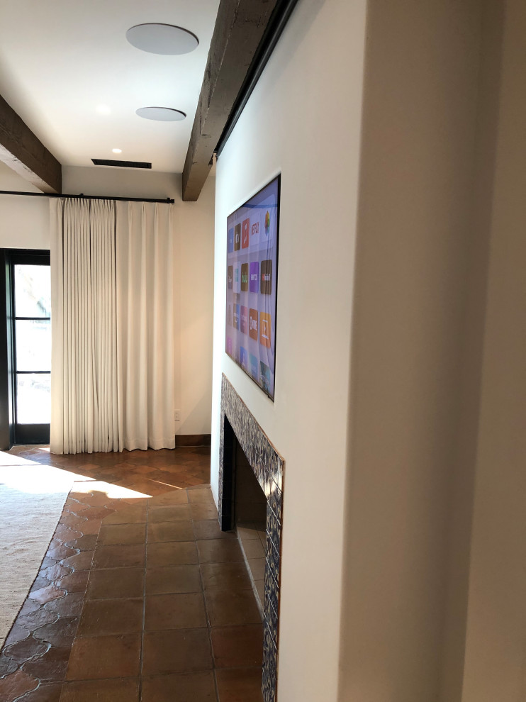 Photo of a medium sized traditional enclosed home cinema in Phoenix with white walls, terracotta flooring, a wall mounted tv and orange floors.
