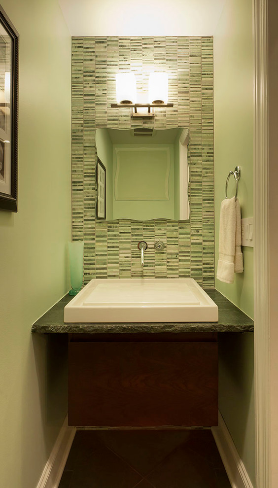 Photo of a transitional powder room in Chicago with a vessel sink, flat-panel cabinets, dark wood cabinets and green tile.
