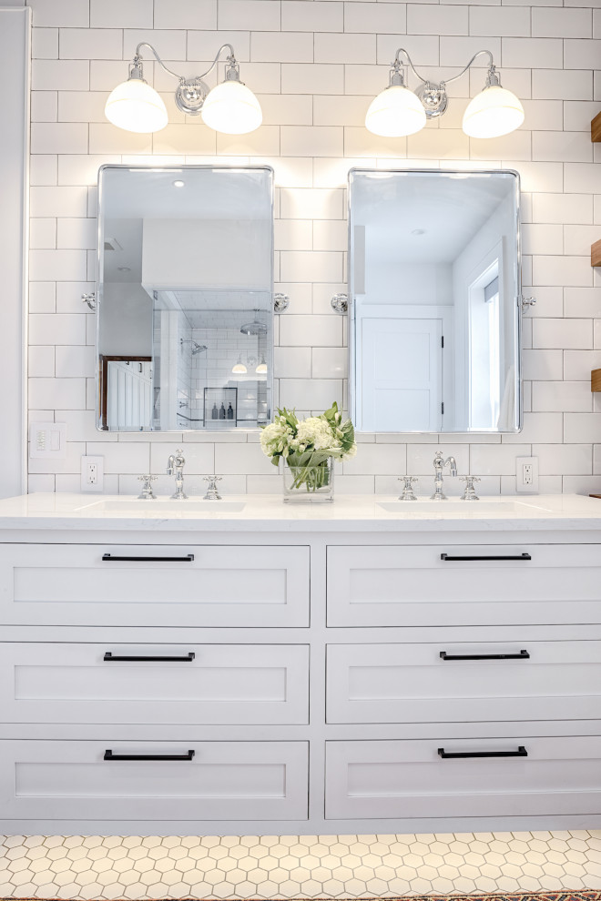 Inredning av ett klassiskt mellanstort vit vitt en-suite badrum, med skåp i shakerstil, vita skåp, ett fristående badkar, en dusch i en alkov, en bidé, vit kakel, tunnelbanekakel, vita väggar, klinkergolv i keramik, ett undermonterad handfat, marmorbänkskiva, vitt golv och dusch med gångjärnsdörr