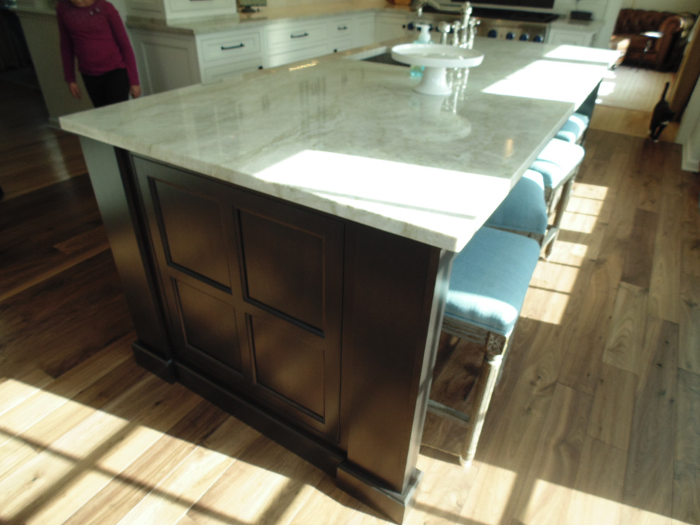 Inspiration for a large transitional u-shaped medium tone wood floor and brown floor eat-in kitchen remodel with an undermount sink, recessed-panel cabinets, white cabinets, quartzite countertops, beige backsplash, subway tile backsplash, stainless steel appliances, an island and beige countertops