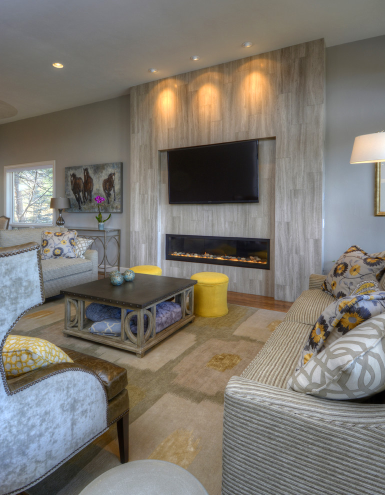 This is an example of a mid-sized contemporary enclosed family room in Denver with grey walls, medium hardwood floors, a ribbon fireplace, a tile fireplace surround and a wall-mounted tv.