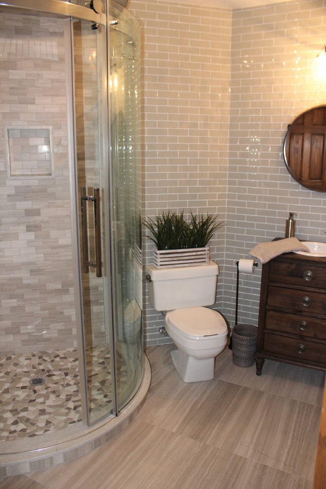 Country bathroom in Toronto with furniture-like cabinets, dark wood cabinets, a corner shower, a two-piece toilet, gray tile, subway tile, grey walls, ceramic floors, a drop-in sink and wood benchtops.
