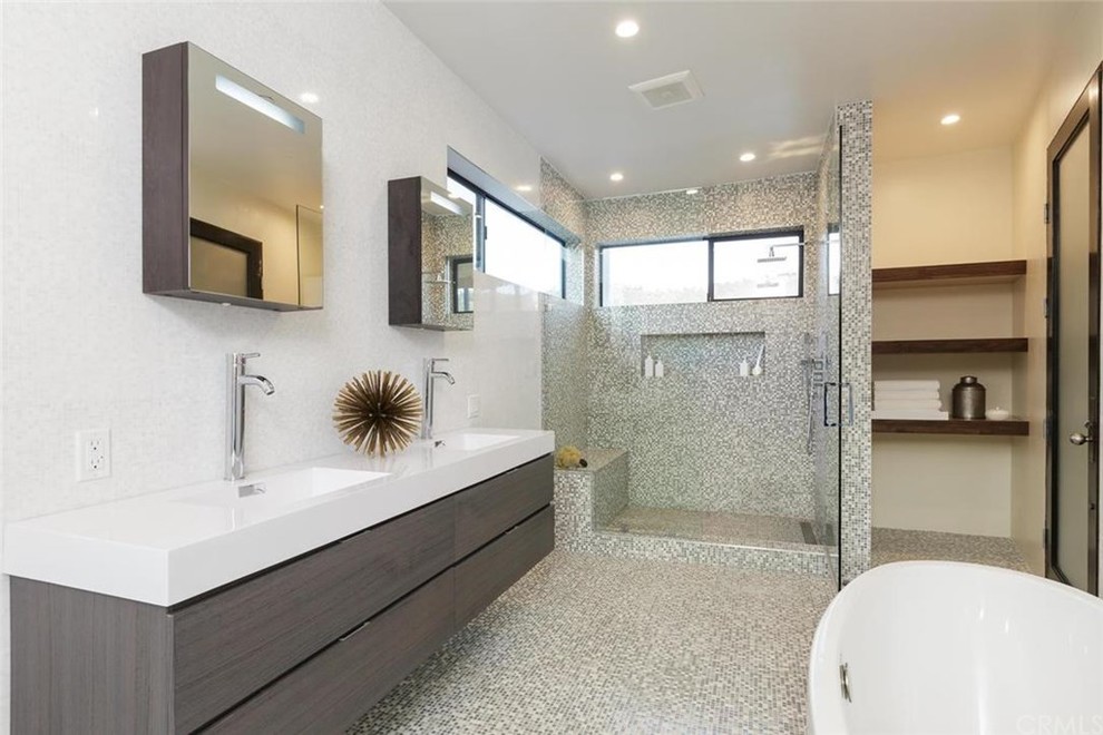 Mid-sized modern master bathroom in Los Angeles with flat-panel cabinets, medium wood cabinets, a freestanding tub, an alcove shower, multi-coloured tile, mosaic tile, an integrated sink, beige walls and mosaic tile floors.
