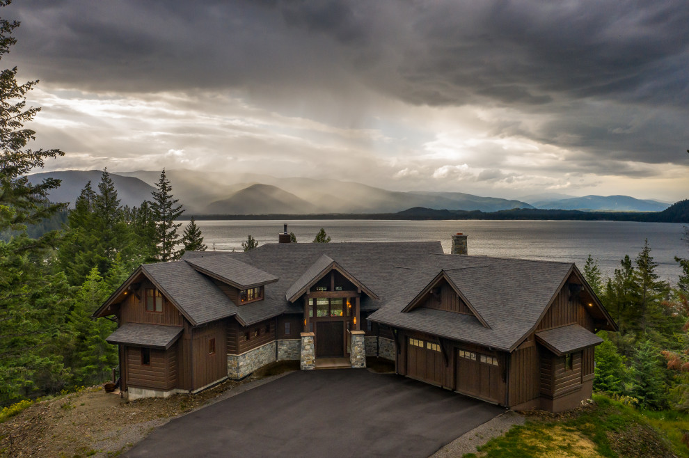 Large mountain style brown three-story wood house exterior photo in Seattle with a shingle roof