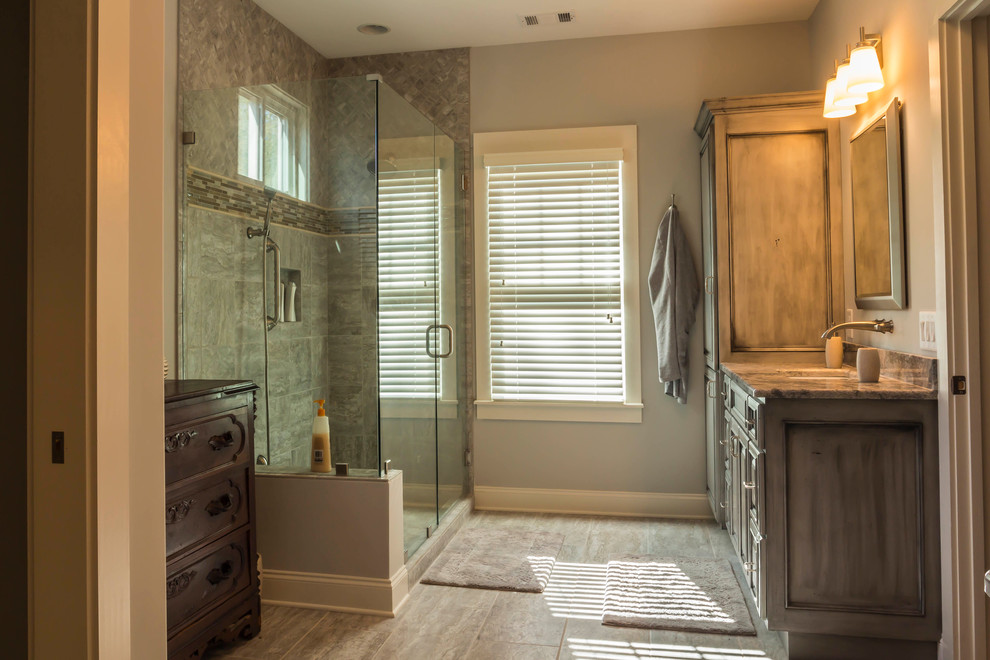 Corner shower - large transitional master gray tile and porcelain tile porcelain tile corner shower idea with an undermount sink, shaker cabinets, distressed cabinets, granite countertops and gray walls