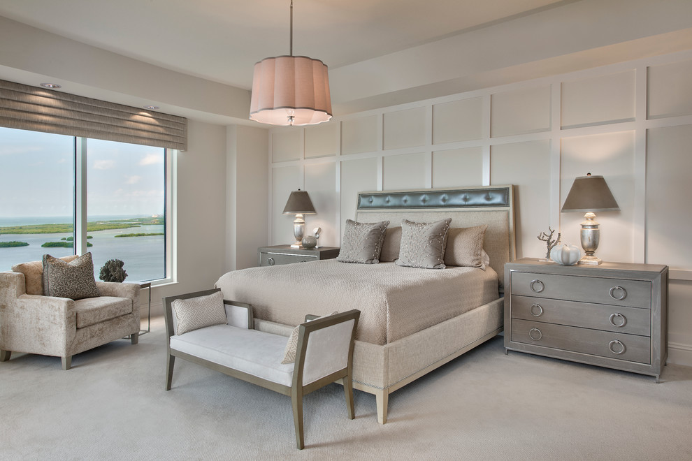 This is an example of a transitional master bedroom in Miami with beige walls and carpet.